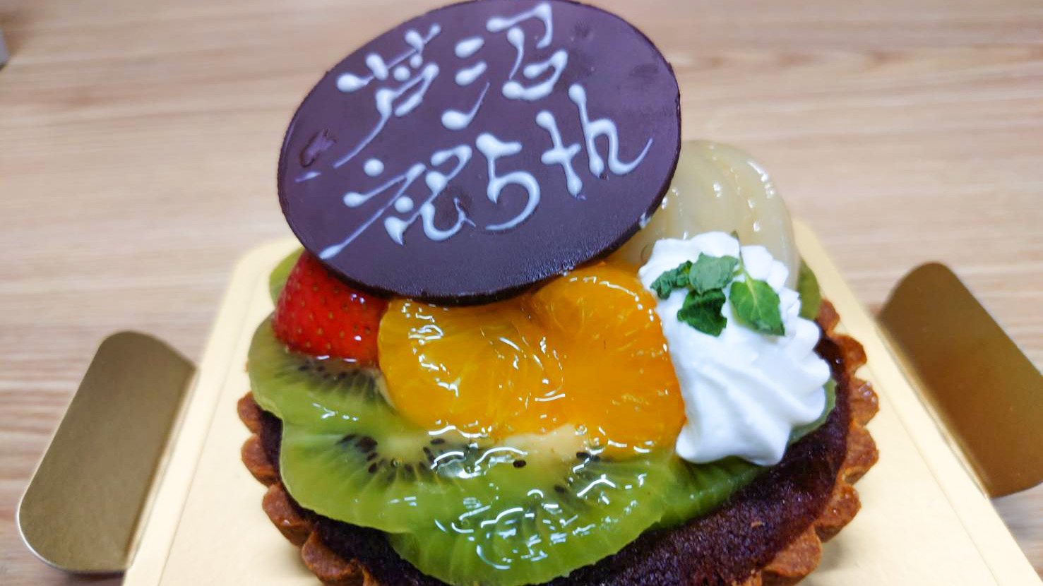 祝芦沼5周年と書かれたチョコレートプレートが乗っているフルーツタルトの写真